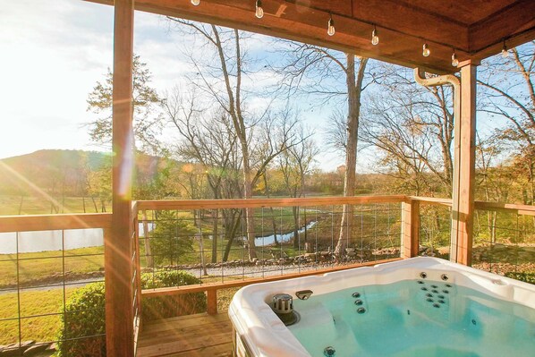 A wooden deck with a hot tub overlooking a scenic landscape with trees and a body of water. - Hilltop Haven • Pool, Hot Tub & Game Loft (Fayetteville)