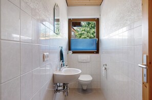 Un baño con lavamanos, inodoro y ventana.