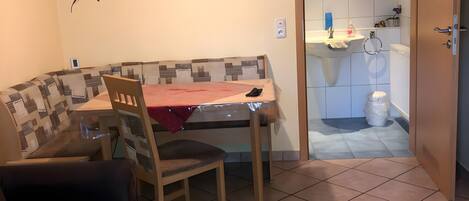 Un coin repas accueillant avec un banc, une table et un luminaire suspendu.