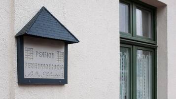 Un cartel de casa con la palabra 'PENSION' y 'FERIENWOHNUNG', indicando una pensión.
