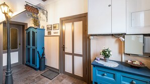 A hallway with a blue cabinet, a door with a sign, and a refrigerator. - Apartment 'Studio Zur »Alten Schmiede«' with Wi-Fi (Laage)