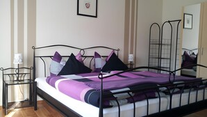 A bed with a metal frame, a wooden floor, and a wall with a striped pattern. - Apartment 'Poll' with Private Terrace, Private Garden and Wi-Fi (Wimbach)