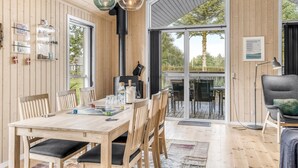 Ein Holzinterieur mit Esstisch, Stühlen und einem großen Fenster.