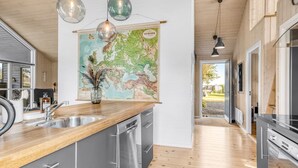 Eine moderne Küche mit Edelstahlgeräten, Holzarbeitsplatten und einer großen Karte an der Wand.