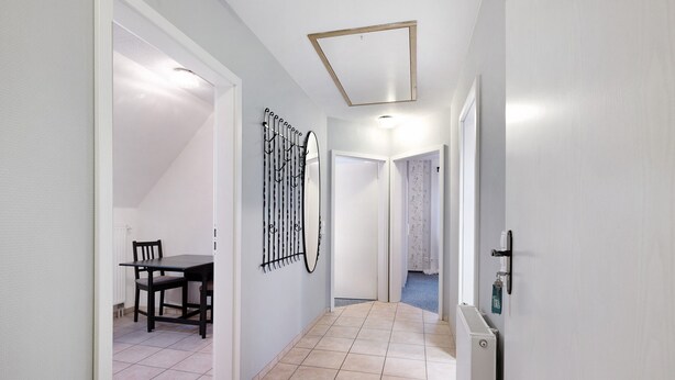 A hallway with a dining area, a radiator, and a door leading to another room. - Apartment 'Ferienwohnung Abendsonne' with Wi-Fi (Lehe)