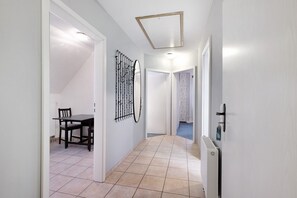 Un couloir comprenant un coin repas, un radiateur et une porte donnant sur une autre pièce.