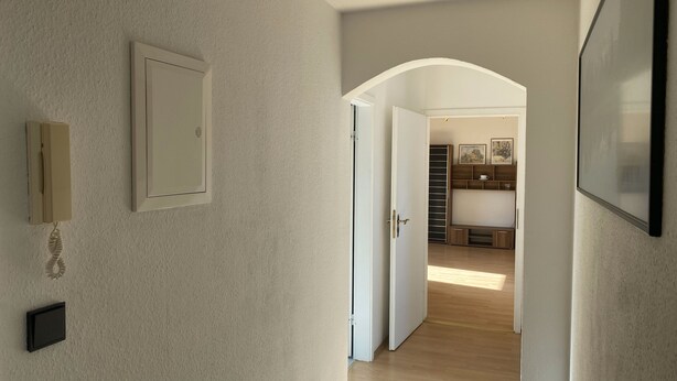 A hallway with a door leading to a room with a wooden floor and a built-in bench. - Holiday Apartment 'An Der Galopprennbahn' with Wi-Fi (Iffezheim)