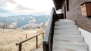 A wooden staircase leading to a building with a view of snow-capped mountains. - Daniele by Interhome (Mühlbach am Hochkönig)