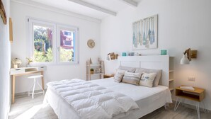 A bedroom with a large bed, a desk, a chair, a window, and a wall-mounted shelf. - Mare Azzurro by Interhome (Valledoria)