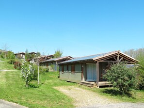 Une rangée de maisons mobiles avec des toits en métal, chacune dotée d’un petit porche et d’une fenêtre.