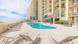 A rooftop pool area with lounge chairs and a swimming pool. - Phoenix IV Condos (Orange Beach)
