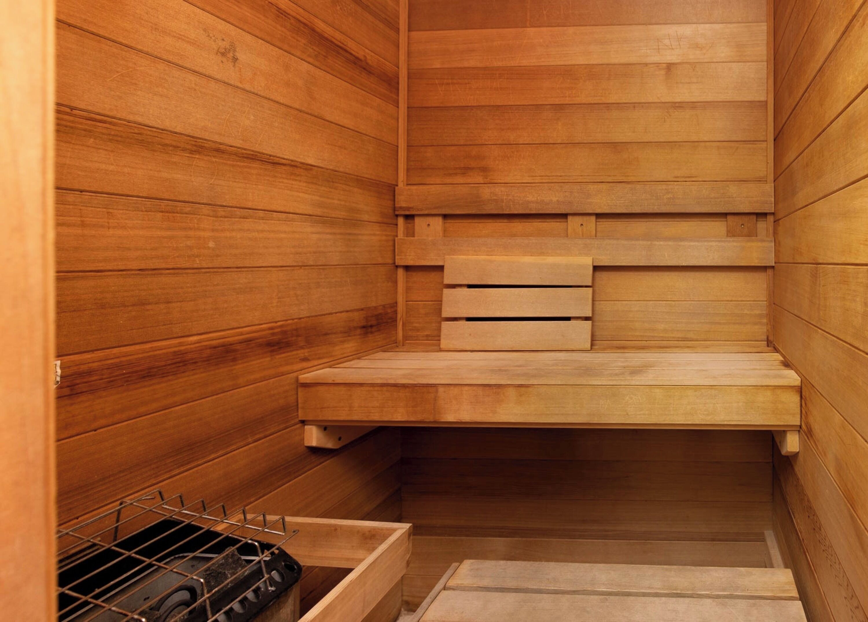 Sauna, jossa on puuseinät ja -lauteet.