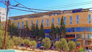 A multi-story building with a row of windows and a covered outdoor area. - Azmal Hotel & Suites (Irbid)