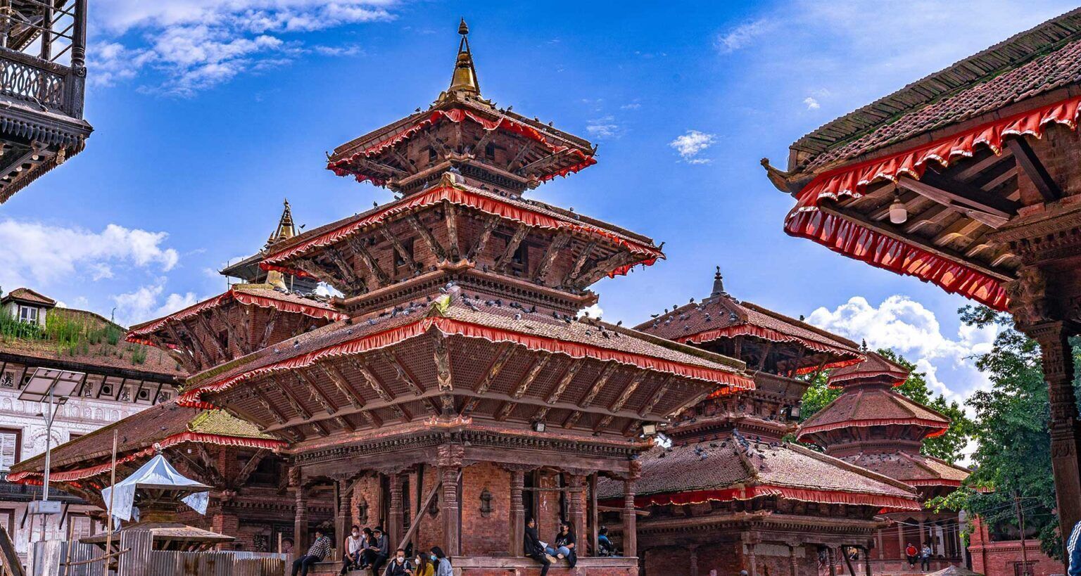 Un temple traditionnel à plusieurs niveaux, doté d’une architecture complexe, se dressant sous un ciel d’un bleu limpide.