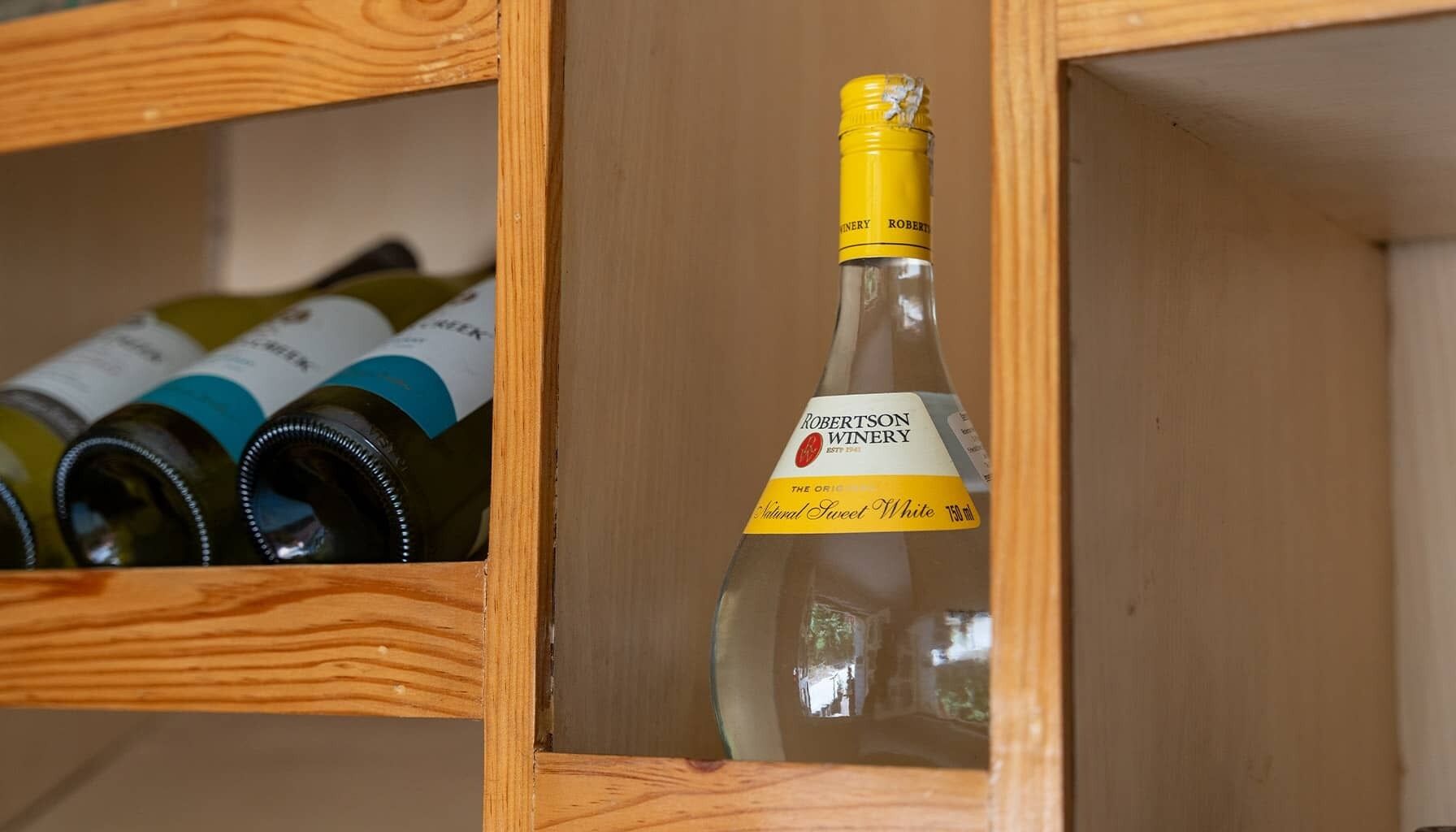 A wooden wine rack with a bottle of Robertson Winery's Natural Sweet White wine.