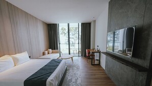 Ένα δωμάτιο ξενοδοχείου με ένα μεγάλο κρεβάτι, ένα γραφείο, μια καρέκλα και μια τηλεόραση τοποθετημένη στον τοίχο.