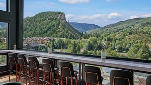 Un restaurante con terraza y vistas a un paisaje montañoso.
