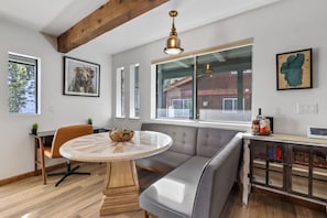 Un intérieur moderne avec une table de salle à manger ronde, un banc rembourré et un meuble en bois.