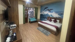 Quarto com cama, espaço para café, televisão e um mural de golfinhos.