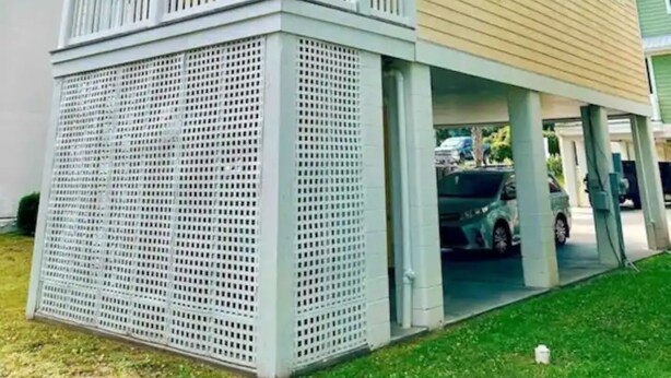 Una casa de dos pisos con balcón y porche cubierto.