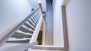 A staircase with white railings and a wooden floor leading to an upper level. - Hybrid Resi - Fulham | 2 Bed Apartment (London)
