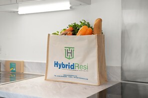 A bag with 'HybridResi' branding, placed on a counter with a stainless steel appliance in the background. - Hybrid Resi - Mitcham | 3 Bed Apartment (Mitcham)