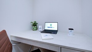 A desk with a laptop displaying 'HybridResi', a plant, a white box, and a book titled 'HybridResi'. - Hybrid Resi - Uxbridge|1 Bed Apartment (Uxbridge)