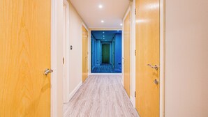A hallway with wooden doors and a blue carpeted area at the end.
