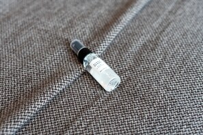 Un flacon de spray pour favoriser le sommeil, posé sur une surface en tissu texturé.