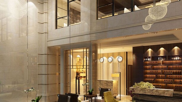 A modern lobby with seating areas, a reception desk, and a wine display. - Mercury Apartment Danang (Da Nang)