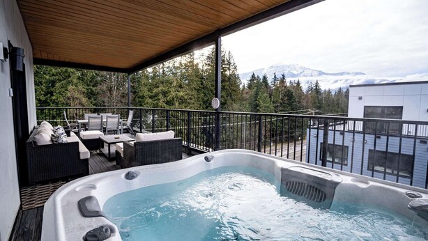 A hot tub on a balcony with a view of a mountain. - Revelstoke - Alpine Retreat (Revelstoke)