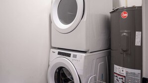 A stacked washer and dryer unit with a control panel and safety labels. - Revelstoke - Alpine Retreat (Revelstoke)