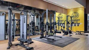 A gym with various weightlifting equipment, a bench, and a motivational wall with the text "COMMIT TO BE GREAT". - HAPPY SEASON I Seven Palm Residences Palm Jumeirah (Dubai)