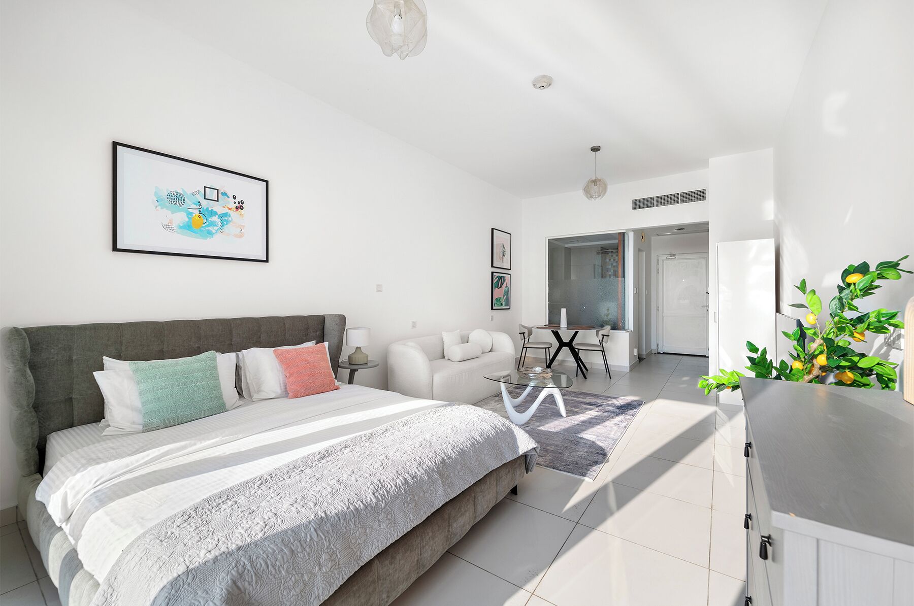 Une chambre moderne avec un grand lit, un coin repas et une cuisine.