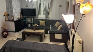 Een woonkamer met een bank, een salontafel, een televisie en decoratieve accessoires.