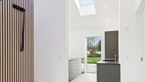 Una cocina moderna con una isla integrada, un tragaluz y vistas al exterior.