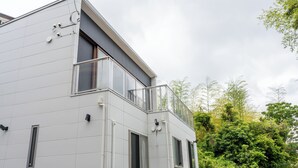 Un edificio moderno de dos pisos con ventanas amplias y un balcón.