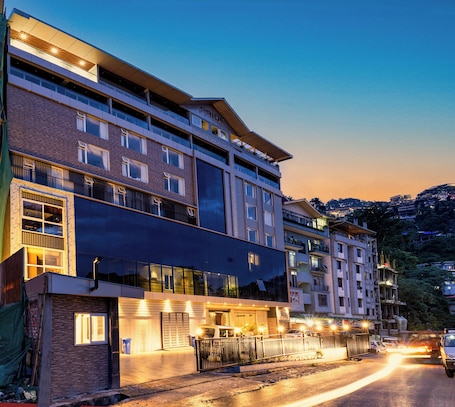 A multi-story hotel with a modern architectural design, featuring balconies and large windows.
