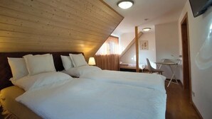 A bedroom with a large bed, a desk, and a chair. - Sustainable, vegan-friendly accommodation at mining nature trail in Schneeberg (Schneeberg)