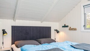 A bedroom with a bed, two bedside lamps, a wall-mounted shelf, and a window. - 4 Person Holiday Home in Oksbol (Oksbol)