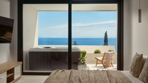 A bedroom with a large bed, a sliding glass door leading to a balcony with a view of the sea. - The Sall Suites Complex B - Sea Views (Zakynthos)