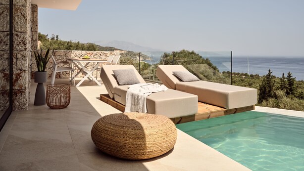 A modern outdoor pool area with lounge chairs, a small table, and a potted plant. - The Sall Suites Complex B - Sea Views (Zakynthos)
