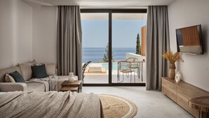 A modern bedroom with a large bed, a sofa, a TV, and a view of the sea through a sliding glass door. - The Sall Suites Complex B - Sea Views (Zakynthos)