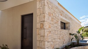A modern building with a stone facade, a dark door, and a small window. - The Sall Suites Complex B - Sea Views (Zakynthos)