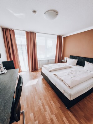 A hotel room with a bed, a desk, and a chair. - Zentral Hotel (Bad Fuessing)