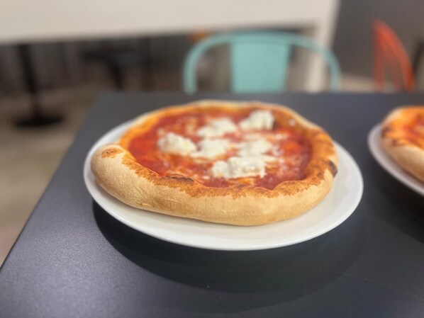 A pizza on a white plate on a table.