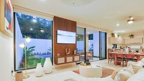 Enjoy a serene view of the garden from the large window in this stylish living room.