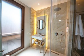 A modern bathroom with a glass-enclosed shower, a white sink, and a mirror. - Green Terrace Apartments Tirana (Tirana)