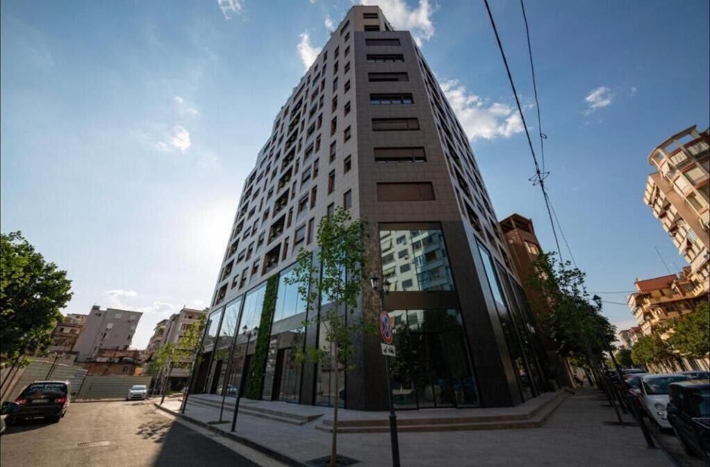 Un edificio moderno y alto con fachada de vidrio y varios pisos.