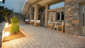 A modern building with outdoor seating and a stone facade. - Mylos 2 apt, Apartment (Agios Nikolaos)